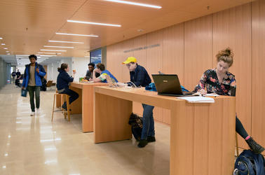 A group of students works at the touchdown desks in the Learning Commons at the Poorvu Center.
